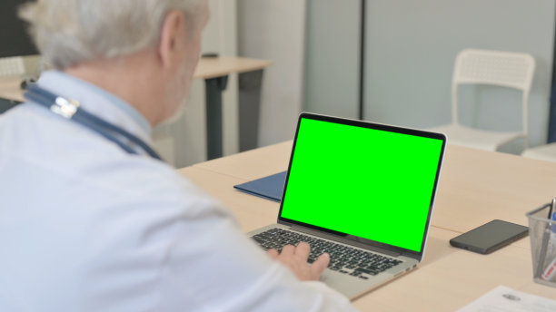 高级医生工作的笔记本电脑与色度键屏幕图片下载