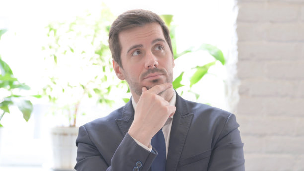 沉思的年轻商人思考新的商业计划的肖像图片下载