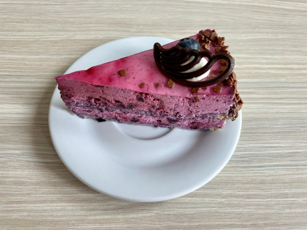 一个白色盘子里的美味的生蓝莓蛋糕，上面有奶油和巧克力图片下载