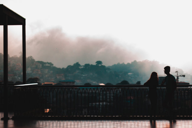 阳台上一对情侣的剪影，雾蒙蒙的景色图片下载