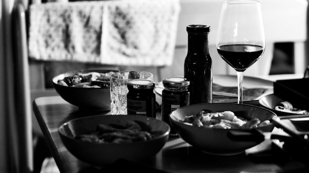 单色镜头的美味海鲜在碗和一杯酒在桌子上图片下载