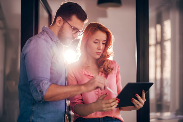 年轻成功人士在现代办公室的平板电脑上分享想法。图片下载