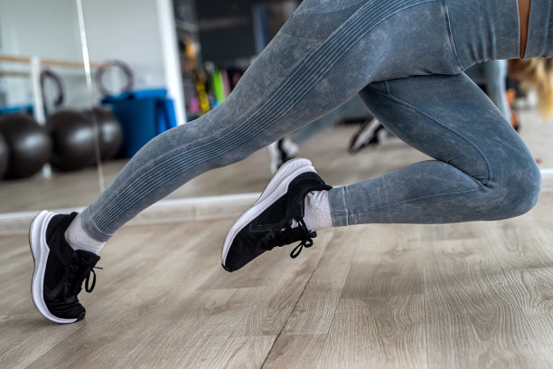 女运动员在运动紧身裤和盘腿炫耀她的运动瘦腿。图片下载