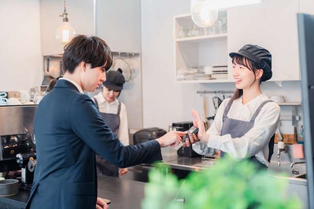 A businessman making a credit card payment at a café图片下载