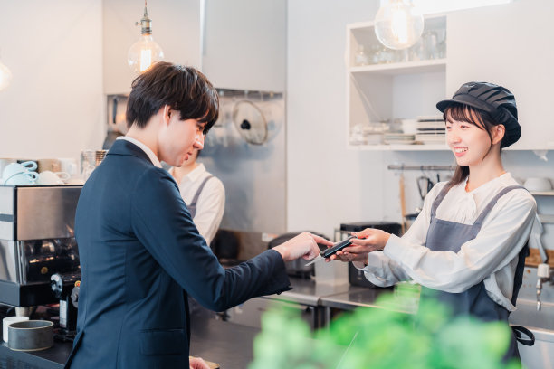 A businessman making a credit card payment at a café图片下载