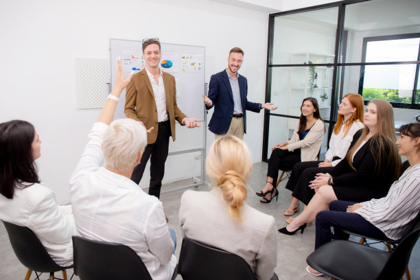 年轻的白人商人在办公室、商业社区和领导会议上展示项目时，一边向员工征求意见和头脑风暴，一边举手共同参与。图片下载
