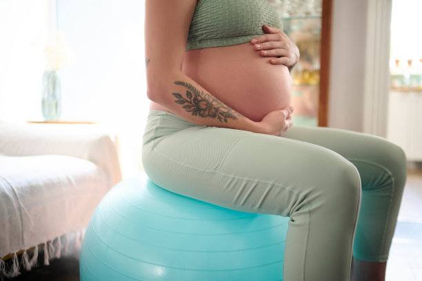 孕妇，瑜伽球和胃的锻炼锻炼，腹部健康或健康的生活方式。怀孕时，在家装备和坐在客厅进行强健身体、冷静健身或平衡训练图片下载