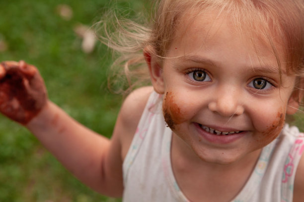 凌乱的小女孩在公园里对着镜头微笑图片下载