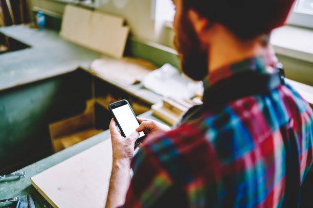 工匠在工作场所使用智能手机图片下载