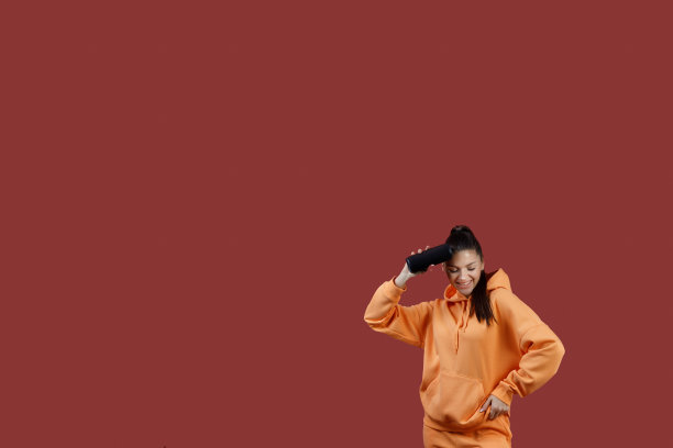 年轻积极的妇女听到便携式无线扬声器。听蓝牙音乐，跳舞图片下载