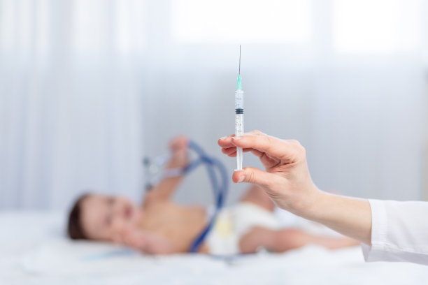 医生的手拿着注射器，背景是一个小孩，儿科医生正在给一个婴儿注射图片下载