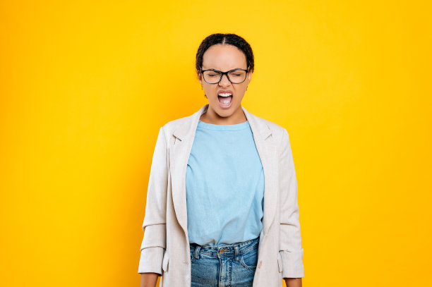 愤怒的西班牙或巴西商业女性，公司雇员，穿着优雅，戴着眼镜，闭着眼睛尖叫，在不自己的愤怒中，站在孤立的橙色背景上图片下载