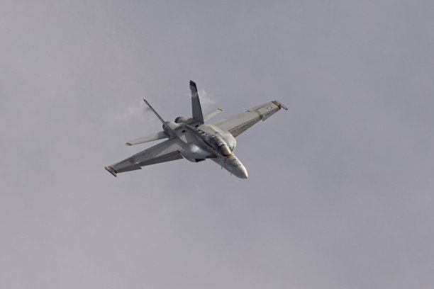 F-18“大黄蜂”战斗机高G机动飞行，机翼根部和垂直尾翼处有凝结尾迹的顶部视图图片下载