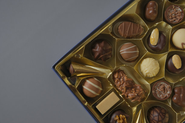 巧克力盒。各色巧克力糖果装在灰色背景的盒子里。牛奶巧克力糖果。糖果和甜点。各式糖果盒图片下载