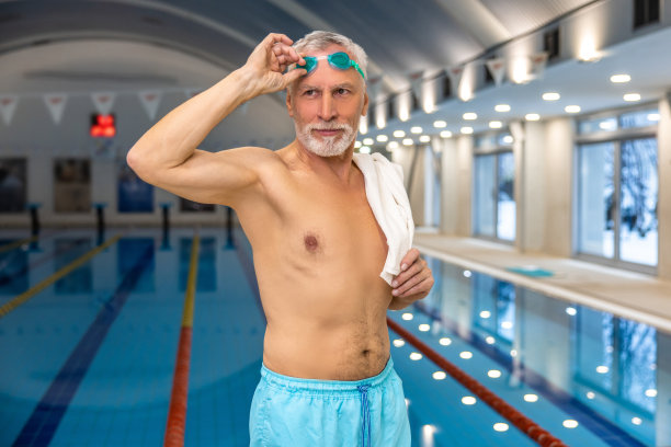 高级男子游泳运动员在游泳池图片下载