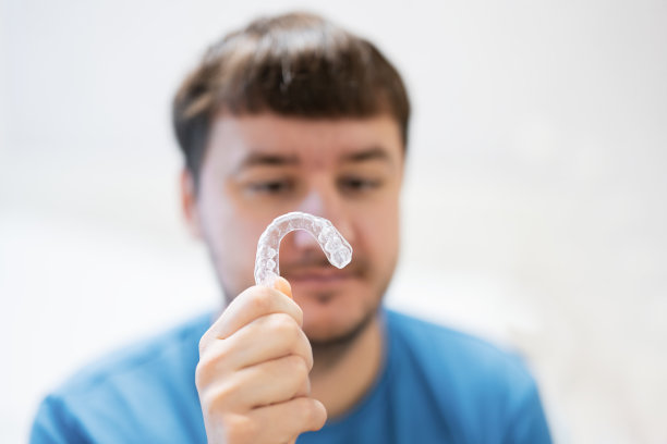 用于牙科矫正的移动正畸器械。男子穿着正畸硅胶训练器或隐形牙套矫正器。图片下载