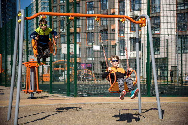 两个欧洲男孩在暑假里荡秋千。孩子们在户外玩得很开心图片下载