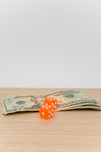 木制桌上放着美元钞票和骰子图片下载