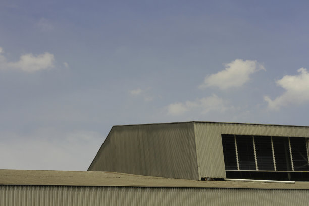 在印度尼西亚雅加达，一座顶部有许多窗户的建筑物的顶部，映衬着蓝天图片下载