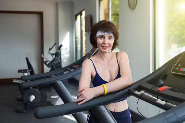 一个褐发女人的肖像在模拟器附近的健身房图片下载