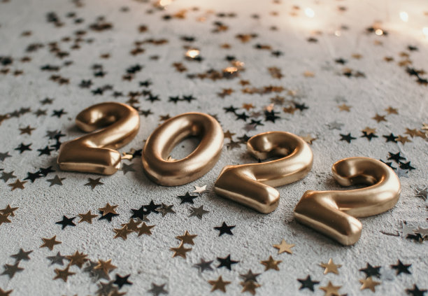 金色数字2022的特写照片，洒着五彩纸屑的混凝土表面图片下载