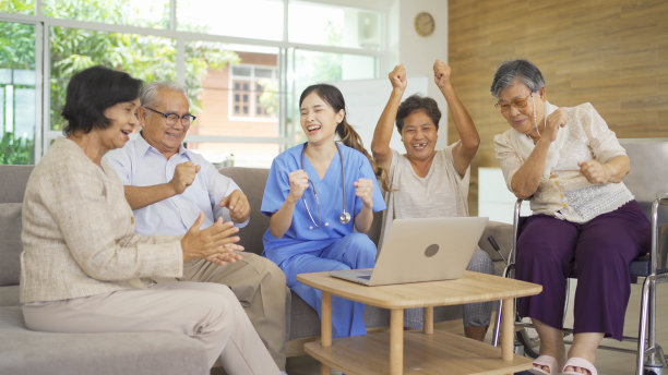 一位亚洲护士与一群老年病人或领取养老金的人交谈，他们微笑着，放松着，一起在养老院玩耍。高级生活方式活动娱乐。退休。卫生保健图片下载
