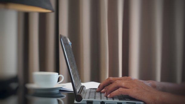 亚洲自由职业者使用笔记本电脑，而坐在客厅的教练。在家在线工作图片下载