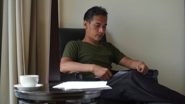 休闲的商务人士或大学生坐在家里的客厅里阅读文件图片下载