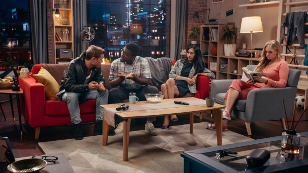 电视情景喜剧概念。四个不同的朋友在客厅里玩耍。电视节目有趣的小品解释简单的事情。网络频道或流媒体服务上的喜剧剧集截图。图片下载