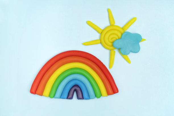 橡皮泥彩虹，云，太阳与光线在蓝色背景。橡皮泥创意，儿童的爱好概念图片下载
