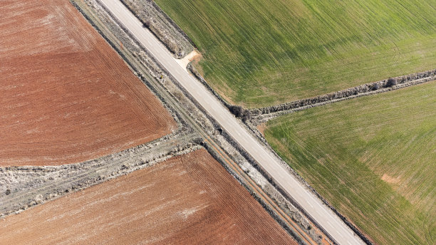 橙色和绿色的耕地被公路穿过图片下载