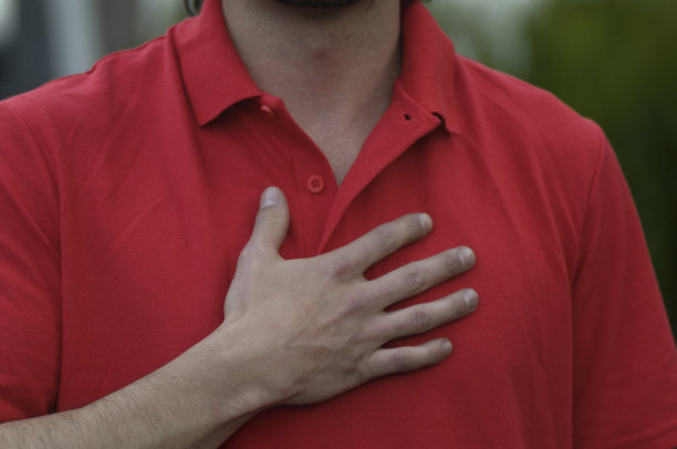 一个穿红t恤，手放在胸前的男人图片下载