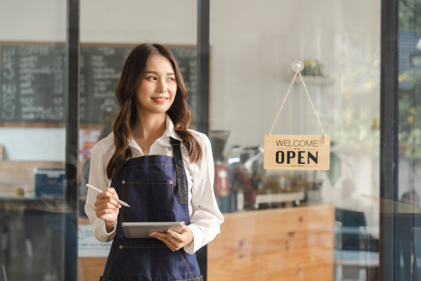Young asia business owner woman with apron with open sign at cafÃ©, open again图片下载