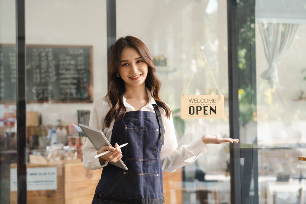 Young asia business owner woman with apron with open sign at cafÃ©, open again图片下载