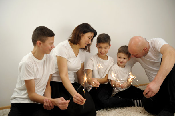 5个人三个儿子，妈妈和爸爸，快乐的家庭在派对上庆祝。一群人在一起聊天。友谊，除夕和节日的概念。图片下载