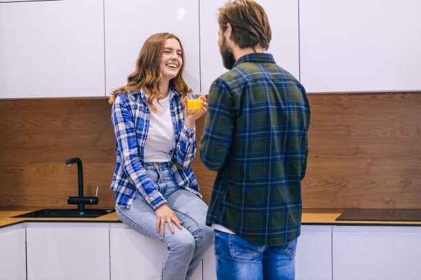 一对浪漫的年轻夫妇在厨房里聊天，有一个图片下载