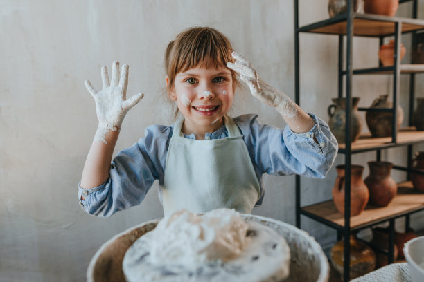 小女孩在制陶轮上摆弄陶土图片下载