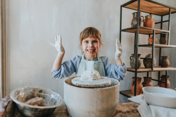小女孩在制陶轮上摆弄陶土图片下载