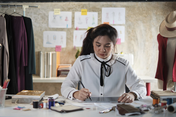 亚洲女性时装设计师通过构思草图来设计服装。图片下载