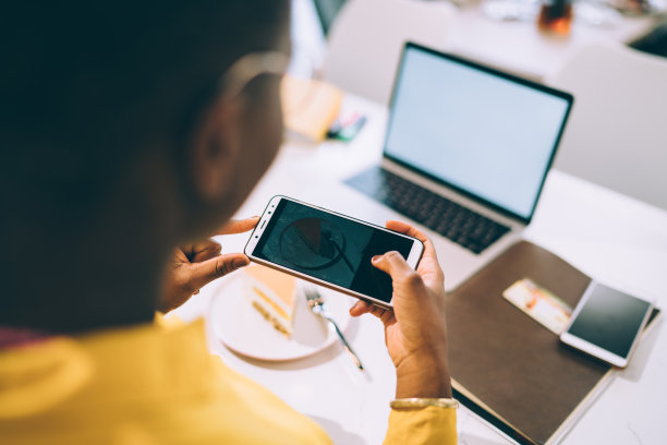 面无表情的女士用手机吃甜点图片下载