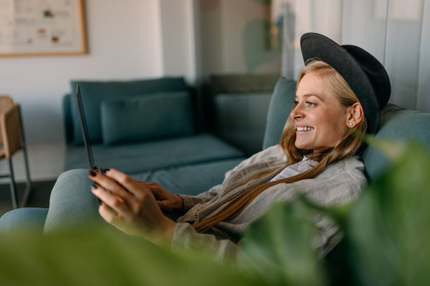 侧视图的一个放松的女人，在线工作，在笔记本电脑。图片下载