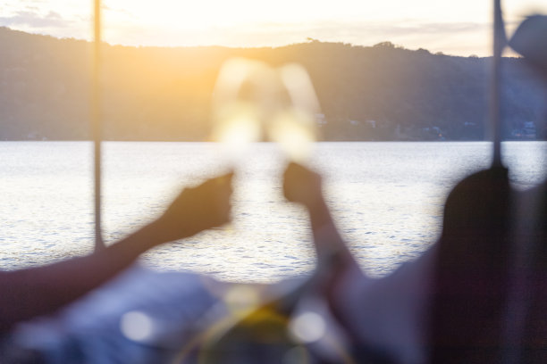 一对情侣在海滨的躺椅上放松，喝着香槟。图片下载