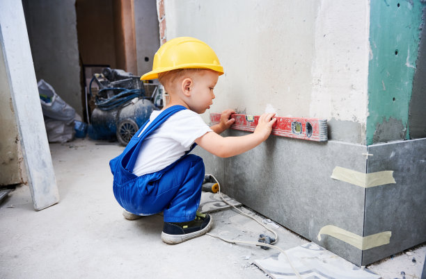 正在装修的公寓，孩子在检查墙上的水位。图片下载