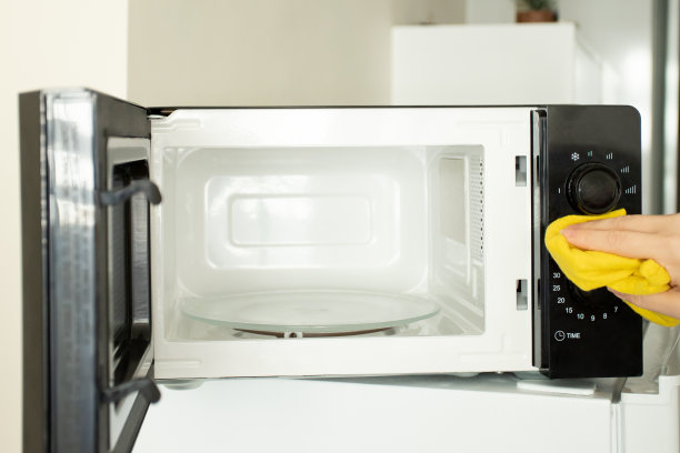 微波炉卫生，女人在清理肮脏的烤箱图片下载