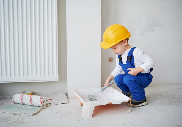 儿童在装修公寓使用油漆辊。图片下载