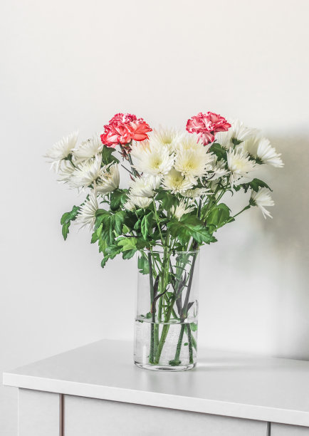 白色桌子上的玻璃花瓶里插着一束菊花图片下载