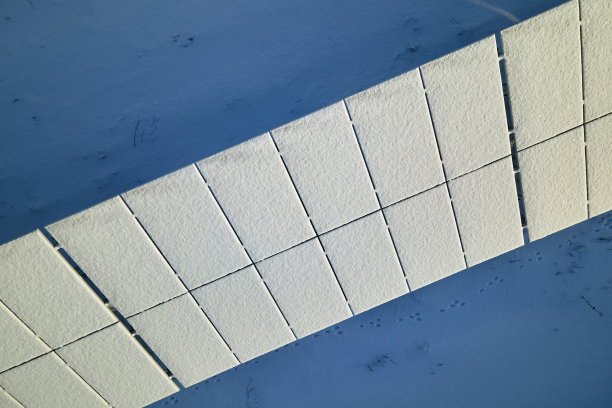 可持续发电厂鸟瞰图，冬季太阳能光伏板被雪覆盖，用于生产清洁能源。北方可再生电力低效率的概念图片下载