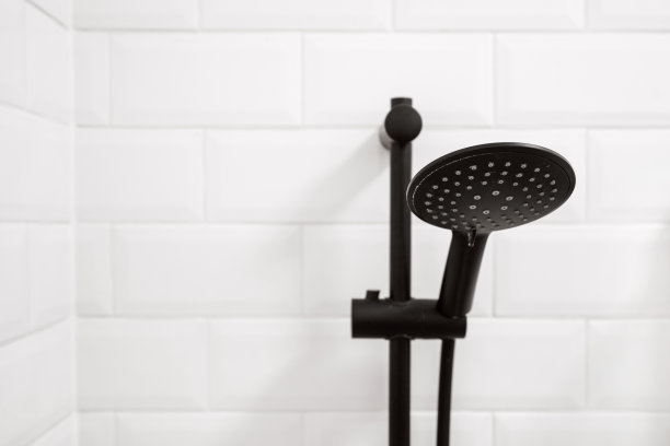 黑色金属淋浴挂在白色墙壁上图片下载