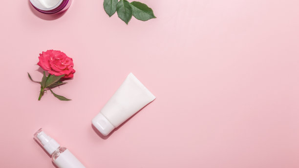 一套护肤产品粉红粉彩背景与玫瑰花。护肤理念。图片下载