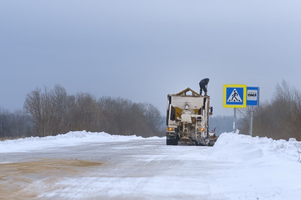 一名工人在车上清理沙子供应。用沙子铺马路的专用车。图片下载